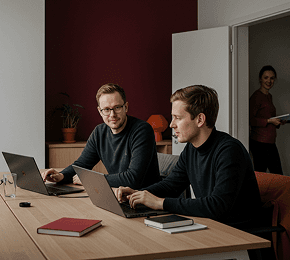 Team members collaborating in a dark-themed office